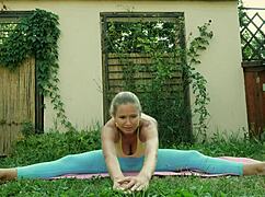 Sexy blonde doing yoga in blue leggings on green meadow, so hot!