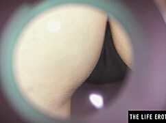 The big-titted brunette beauty explores her hairy pussy with a magnifying glass.