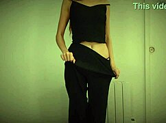 A skinny 18-19 year old girl performs a striptease by undressing and dancing