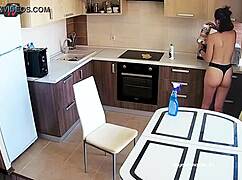 Big tits beauty cleans the kitchen topless, showing off pierced nipples.