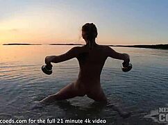 Pretty european girl performs nude fire dancing on usa beach at sunset