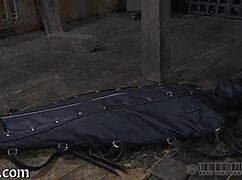 The restrained girl gets punished in the garage.