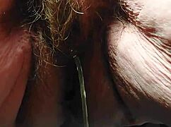 oma inserts cucumber into her hairy pussy for some fun